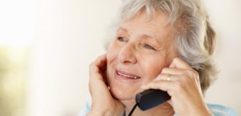 En äldre kvinna talar i telefon
