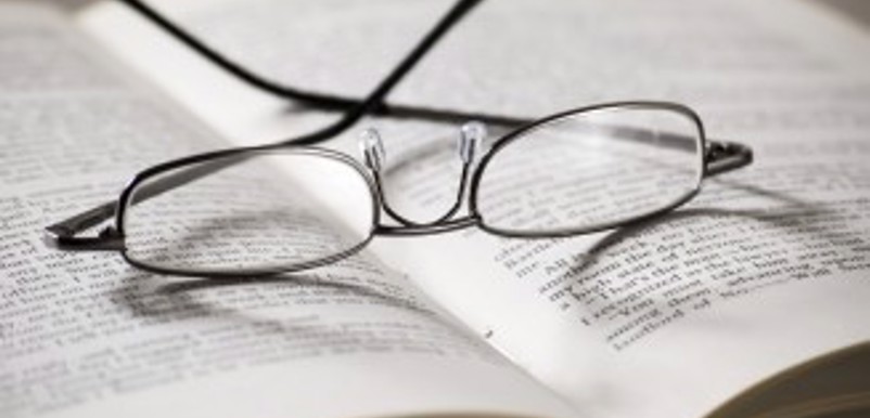 Ett par glasögon i en uppslagen bok